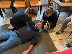 Zwei Teilnehmerinnen nehmen zur Übung einem verunfallten Motorradfahrer den Helm ab